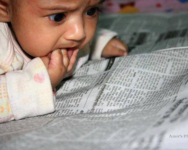 Baby leest geschrokken de krant