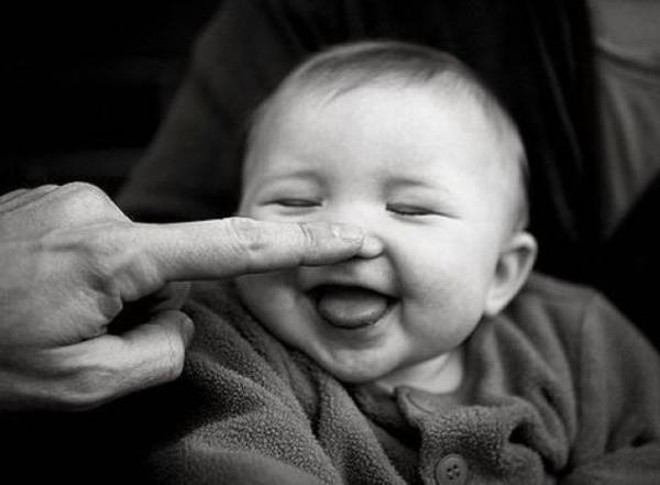 Baby lacht door een druk op de neus